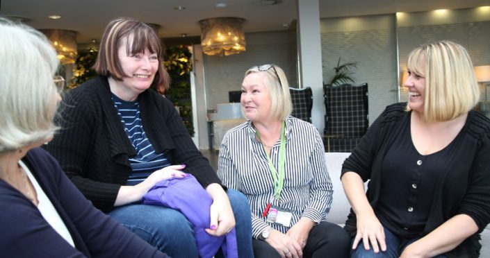 four woman laughing together