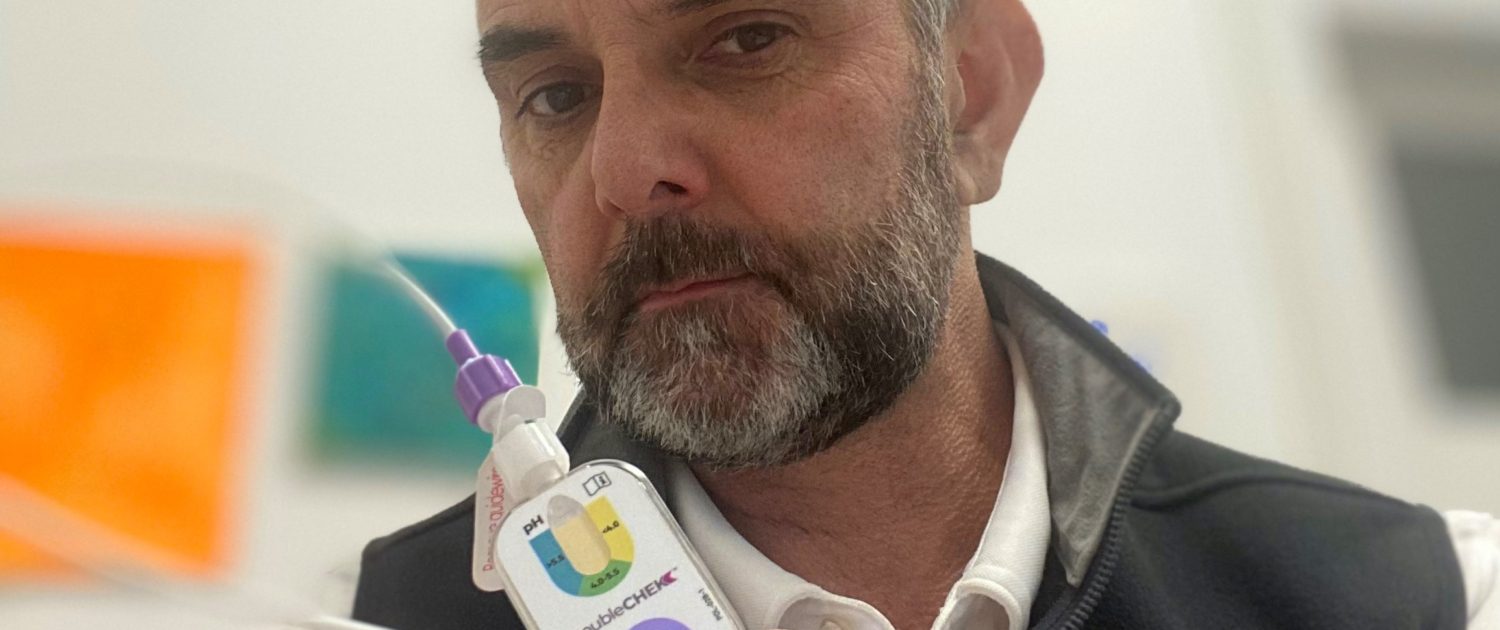 A close up of a mans face holding a tube