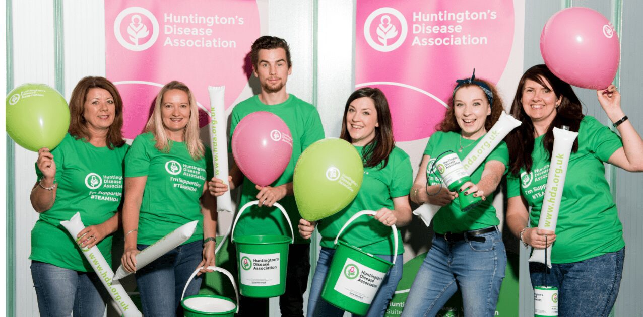 Six people in green t shirts with green buckets trying to raise money