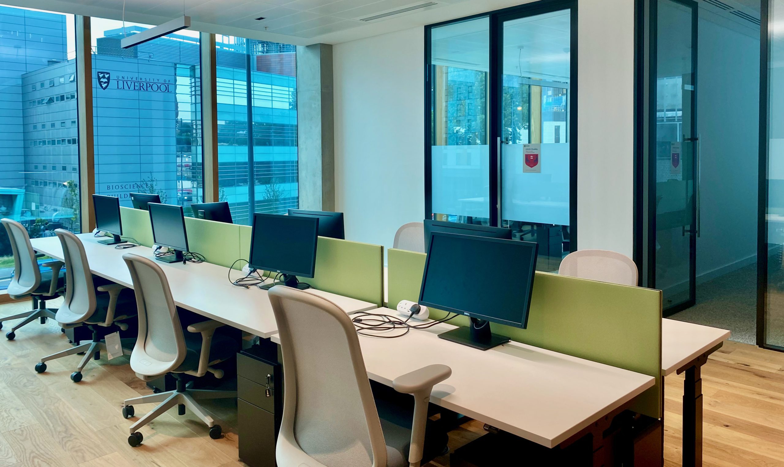 An empty office space with a row of computers and office chair