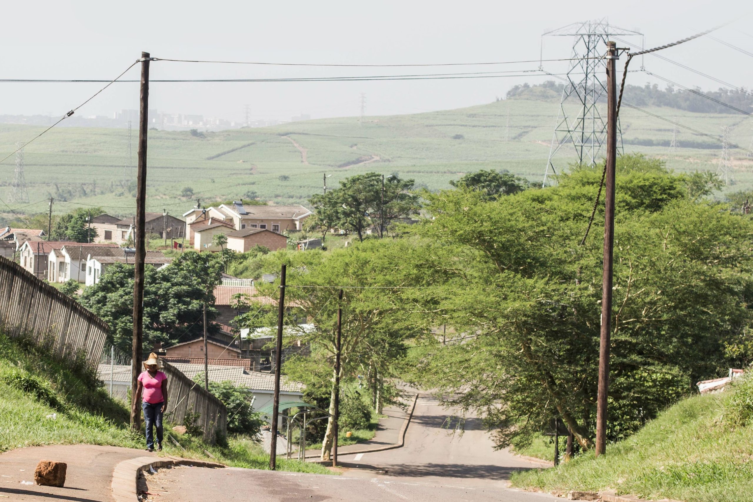 A street in South Africa with someone walking up a hill