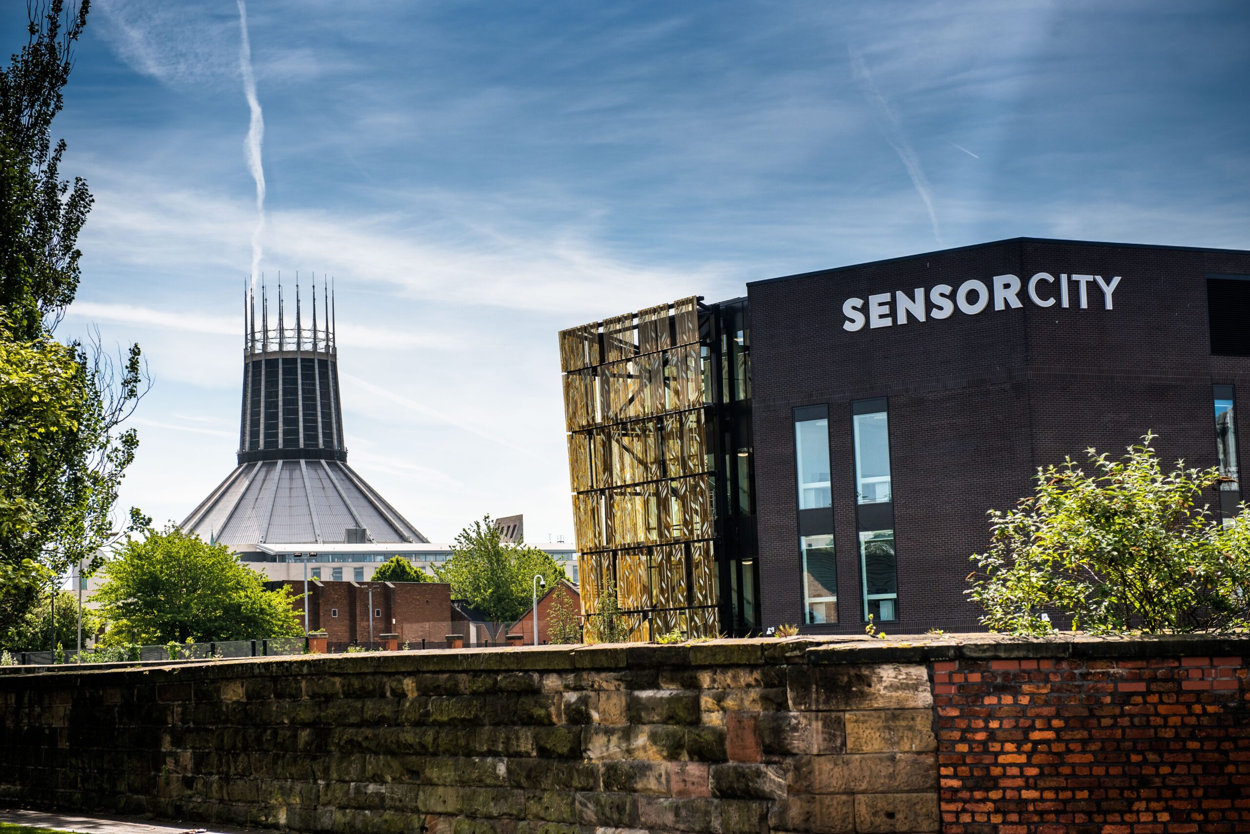 Two buildings in the background in front of a low wall
